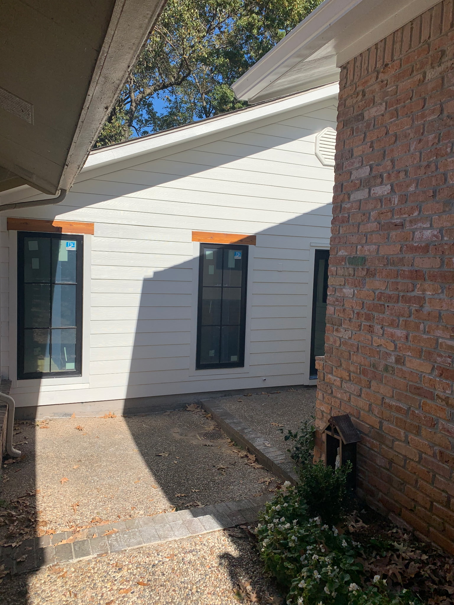 Exterior painting — charcoal finish residential home with timber beam accents, Shreveport LA