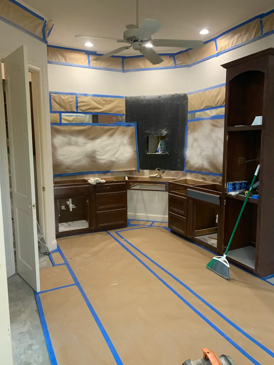 Bathroom cabinets before painting — original dark wood finish with full floor and fixture protection