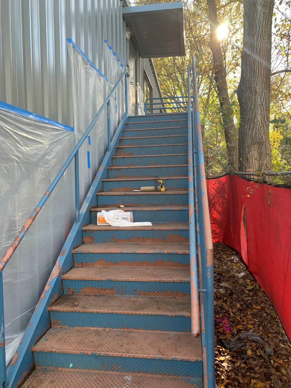 Commercial metal staircase before painting — rusted and peeling paint